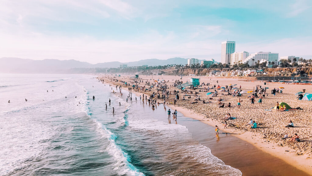 Landscape photo of the beach in Santa Monica looking north, with tall buildings in the background.